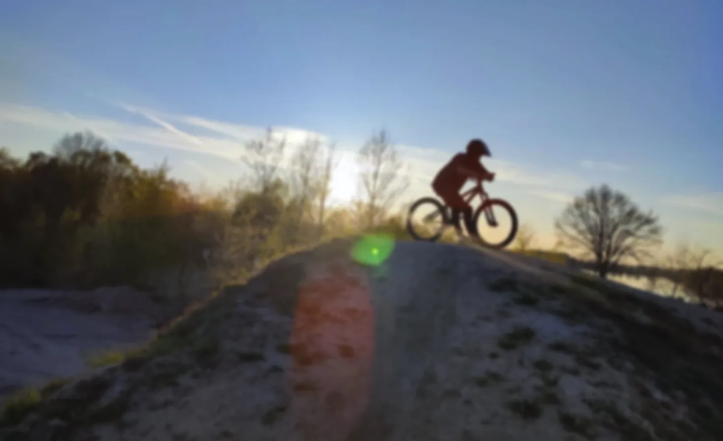 Dirtbike-Fahrer auf der Strecke am Offlumer See bei Sonnenuntergang
